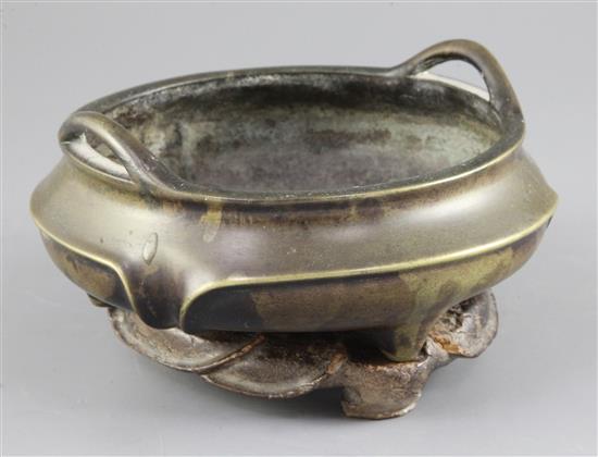 A Chinese bronze tripod censer, ding, 18th / 19th century, diameter 18.5cm, wood stand